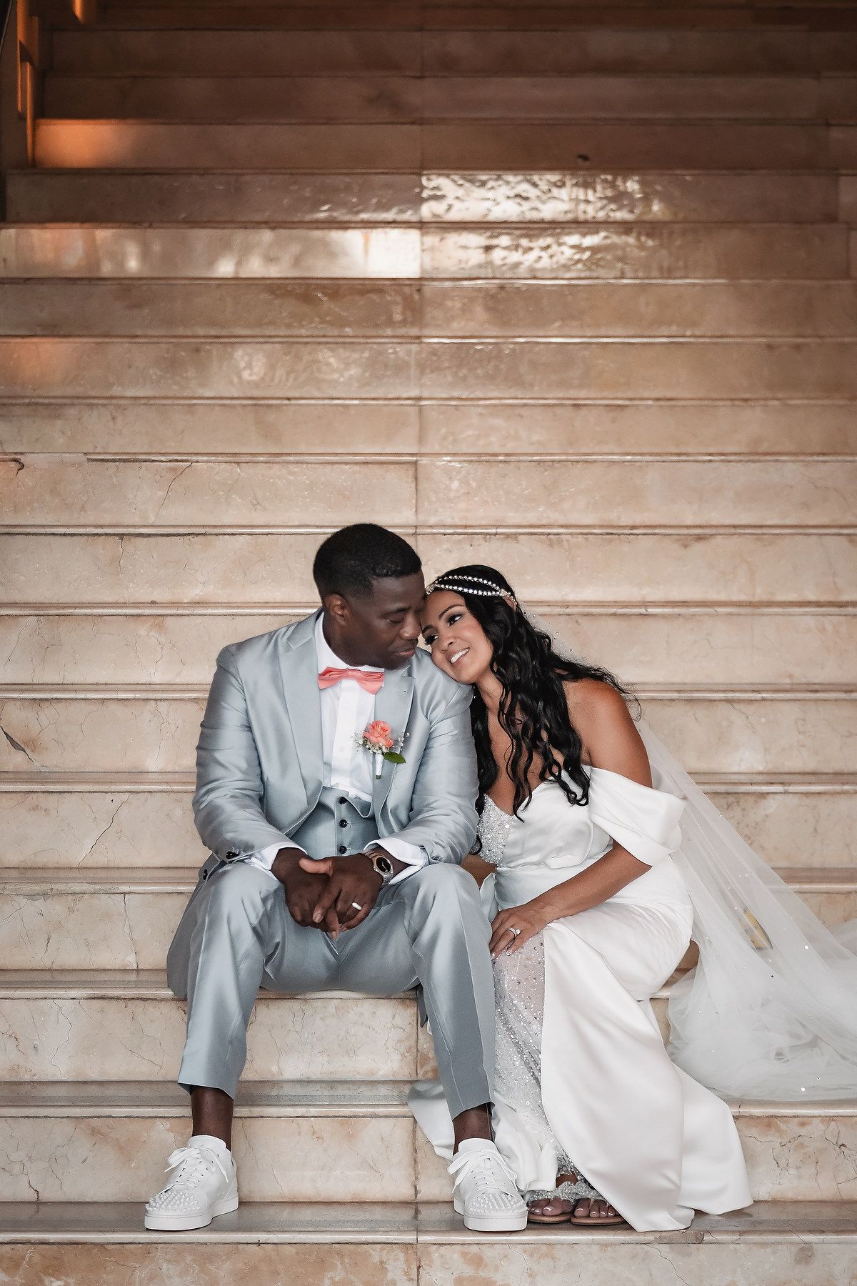 Wedding couple sitting together on wooden steps sharing an intimate moment.