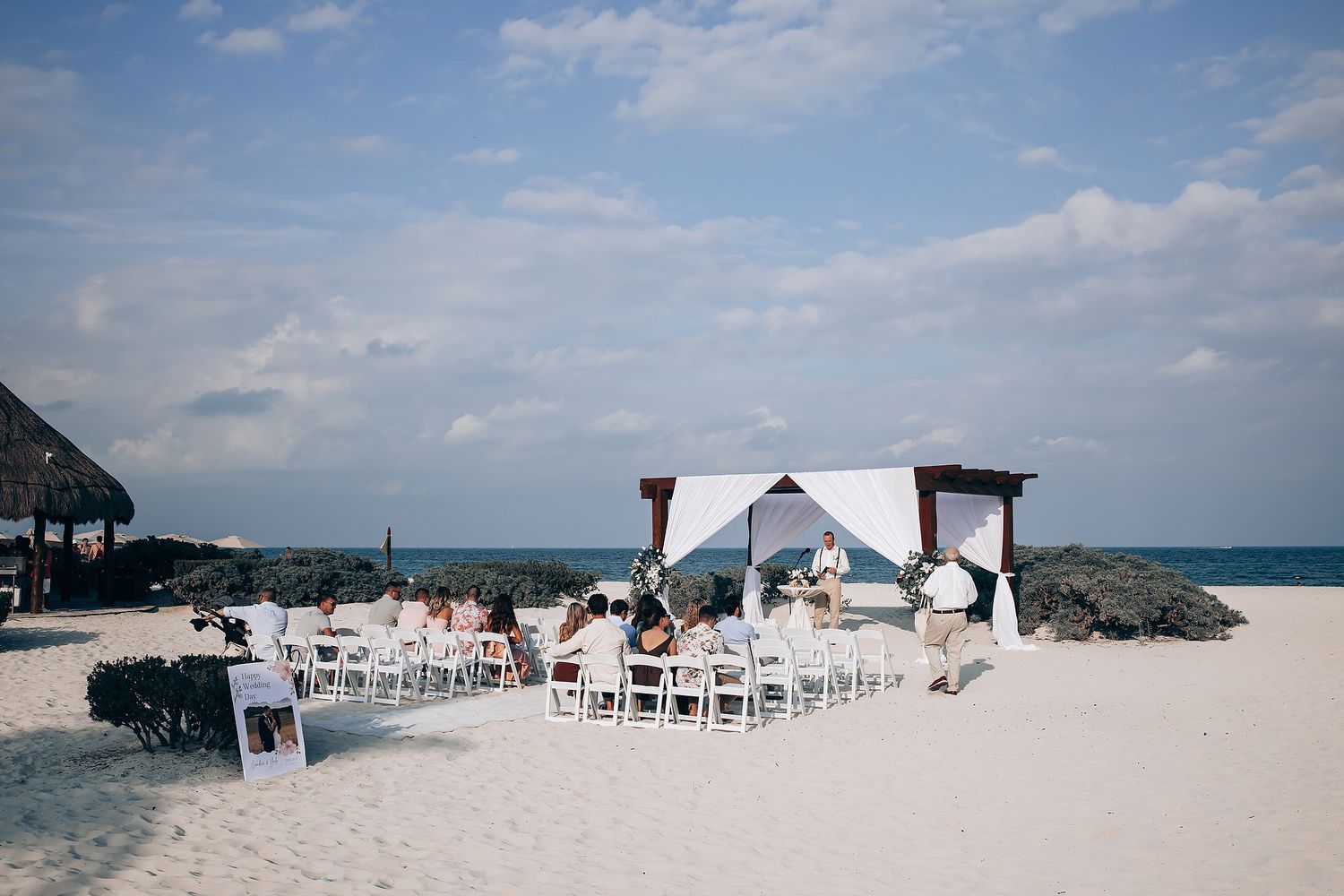White chairs arranged for outdoor beach wedding ceremony with ocean view.