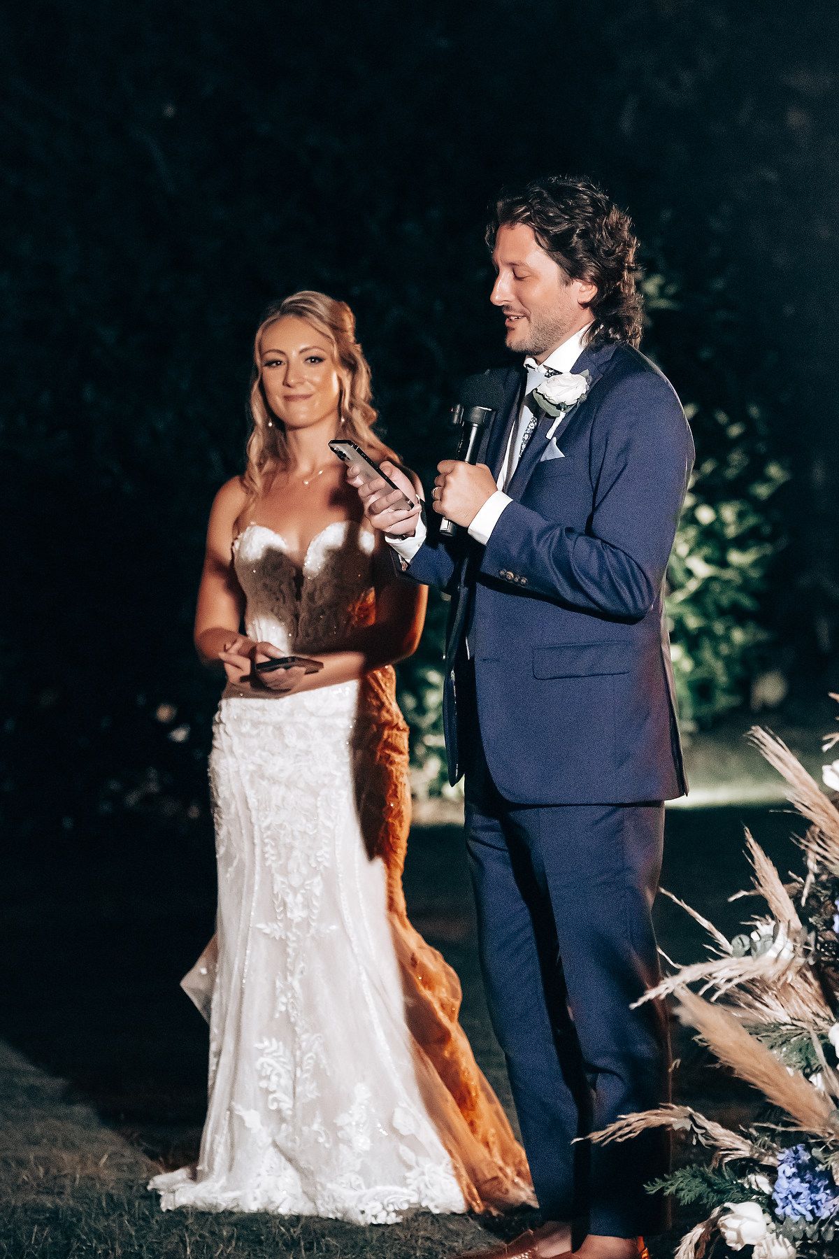 Evening wedding portrait session with dramatic lighting in an outdoor setting.