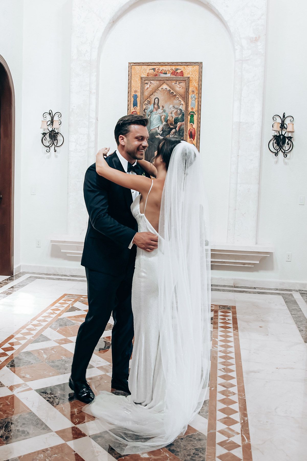 A sequence of wedding photos showing a couple in formal attire sharing a romantic moment in a grand white hallway.