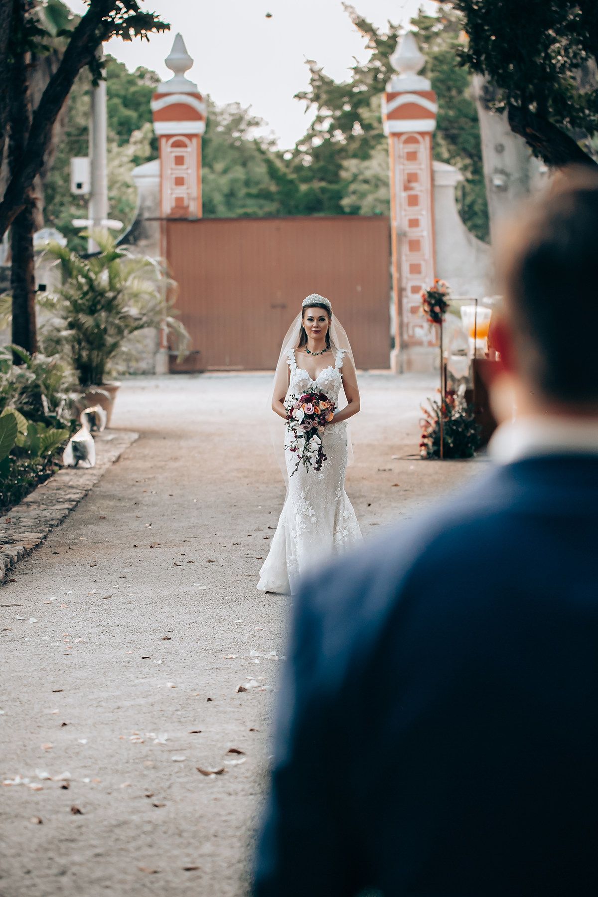 A romantic first look moment between a bride in white and groom in navy during an outdoor wedding ceremony.