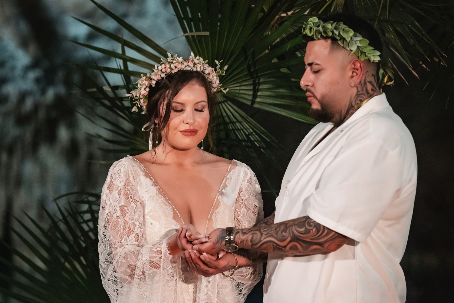 Wedding ceremony moment captured in a mystical cave setting with tropical foliage.