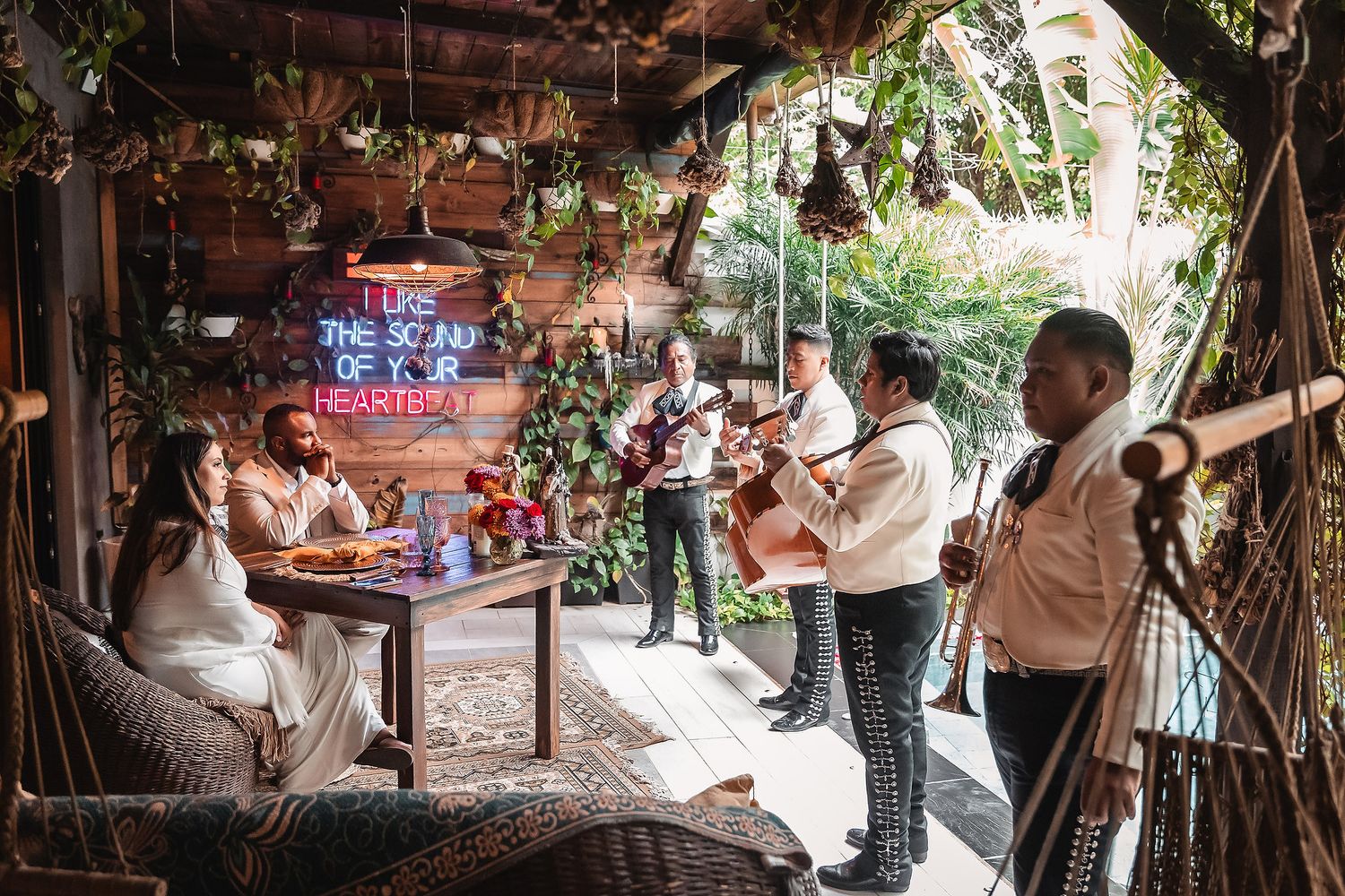 Live band performing at rustic outdoor venue with tropical decor.