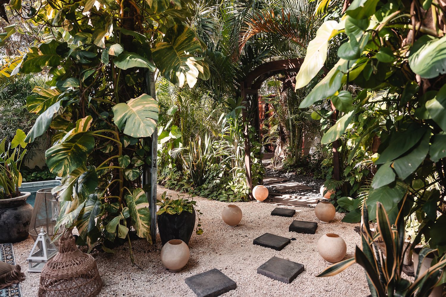 Stone pathway through lush tropical garden with stepping stones and plants.