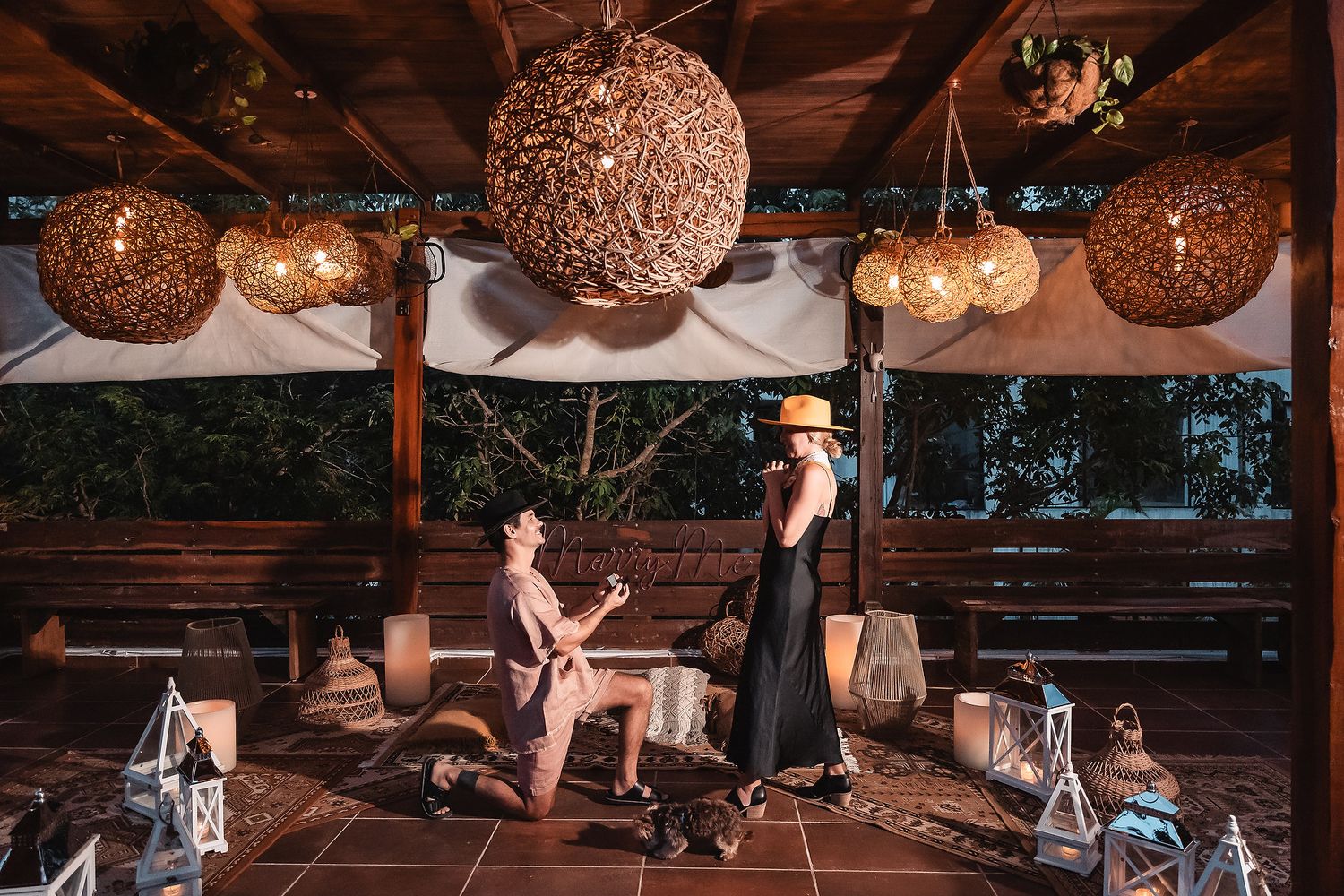 Evening event space with warm lighting from suspended woven orb lanterns.