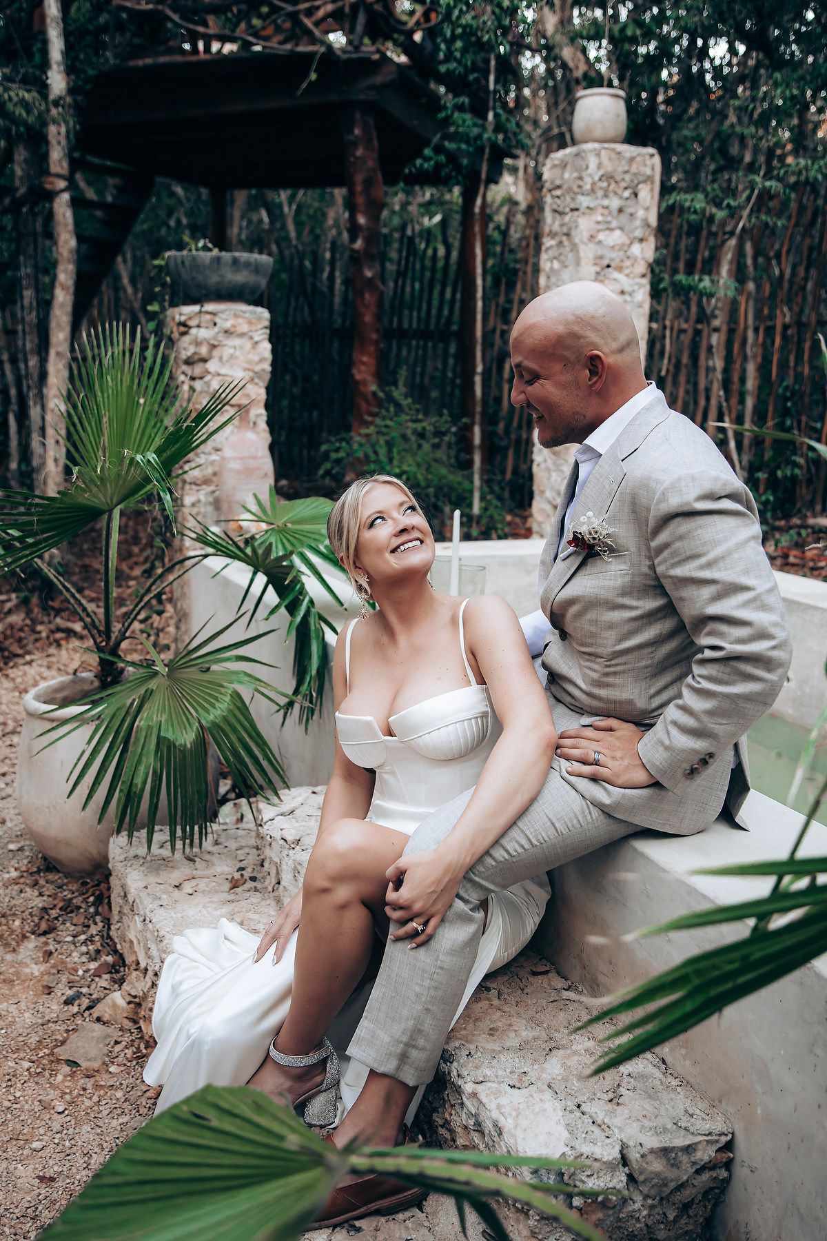 Couple shares romantic moments on stone steps surrounded by tropical palms.