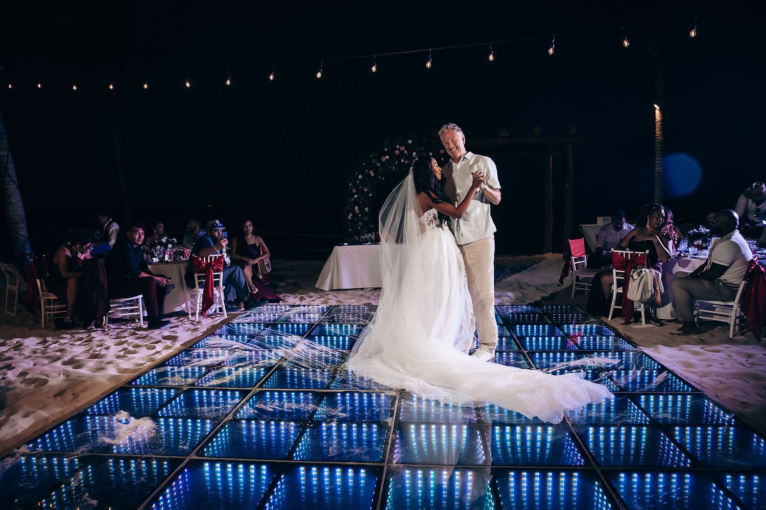 Illuminated dance floor with string lights creating a magical atmosphere at night.
