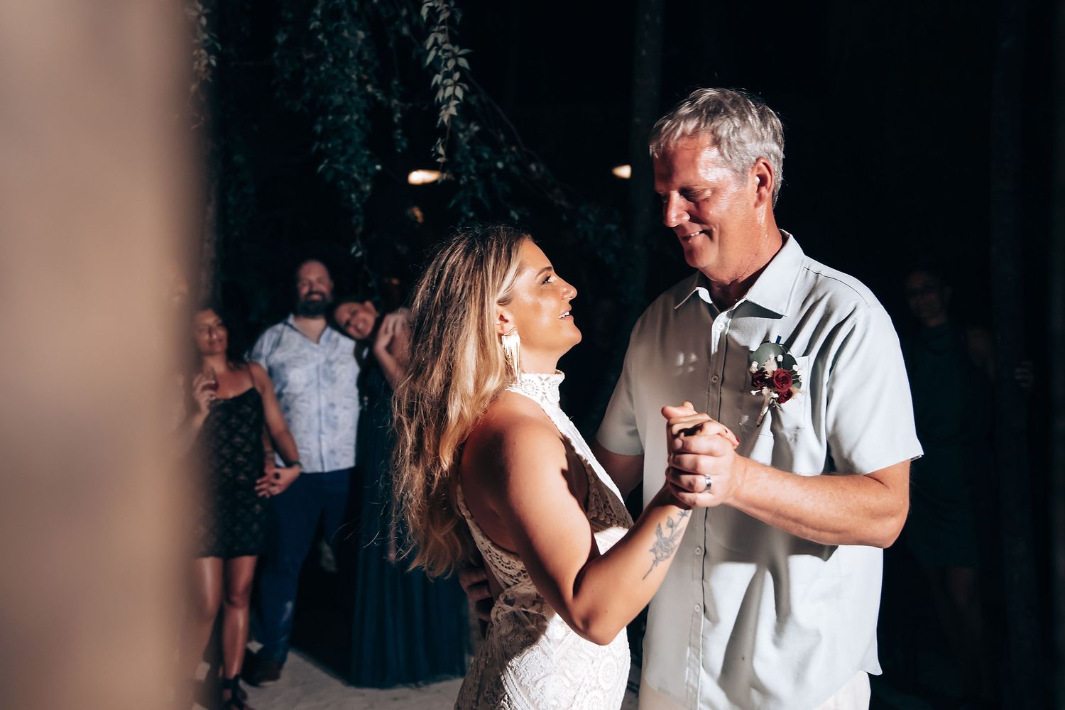 A romantic first dance sequence between a couple at their wedding reception in a dimly lit venue.