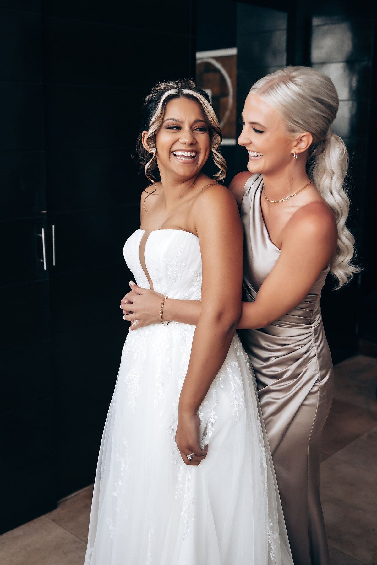 Two people in formal attire sharing a joyful embrace.