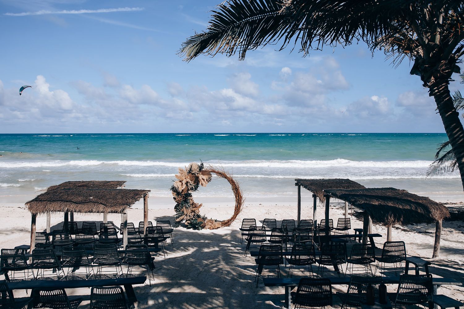 Panoramic view of empty beach chairs facing crystal blue waters and white sand beach.