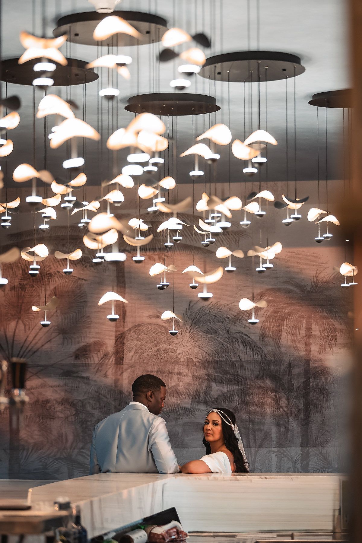 Modern reception venue with artistic hanging light fixtures creating ambient atmosphere.