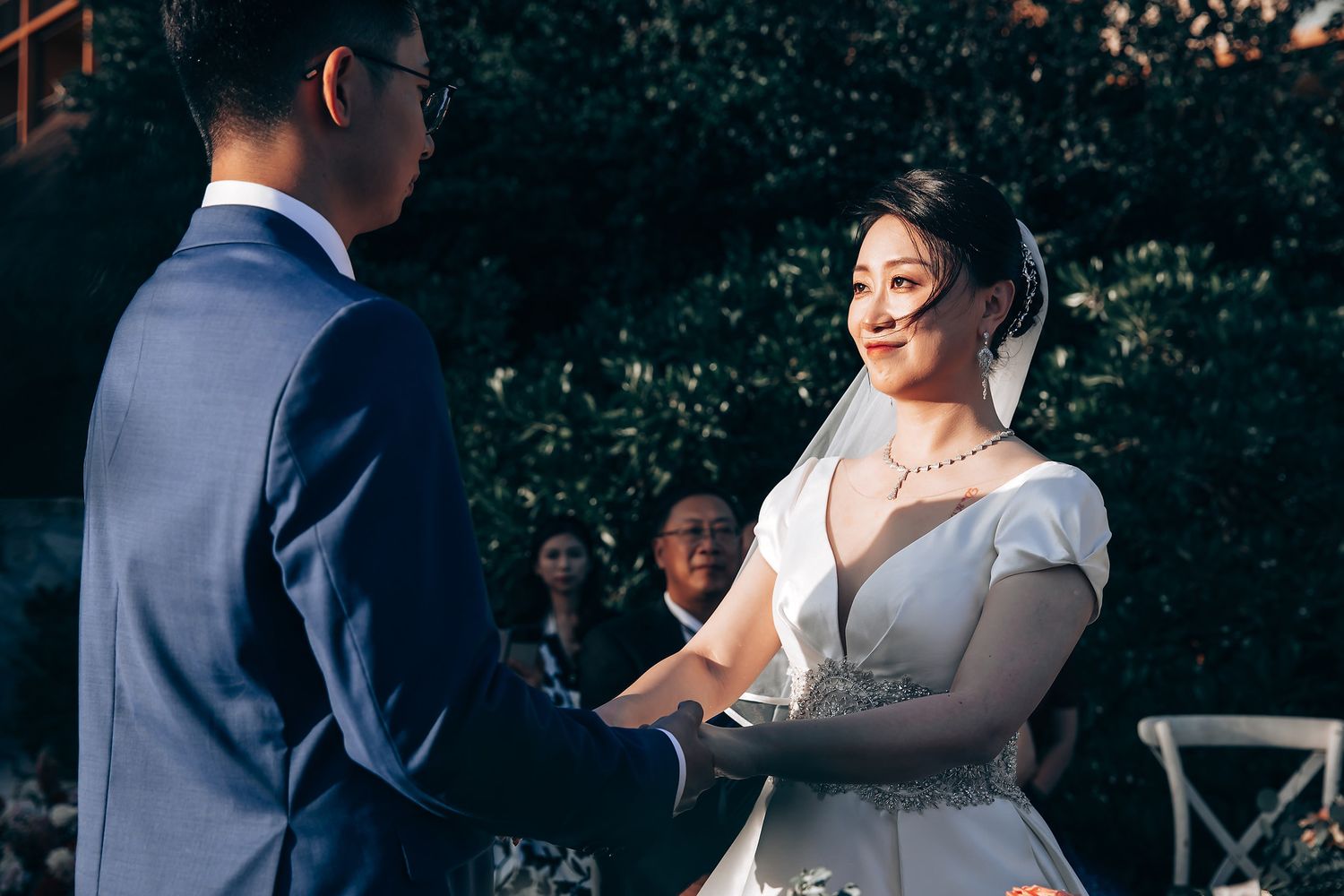 Elegant wedding ceremony moment captured outdoors with floral decorations.