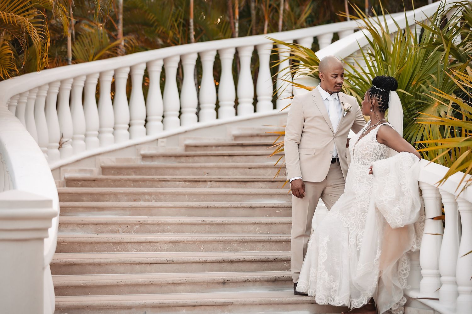 White marble staircase with decorative balusters extends across tropical garden setting.