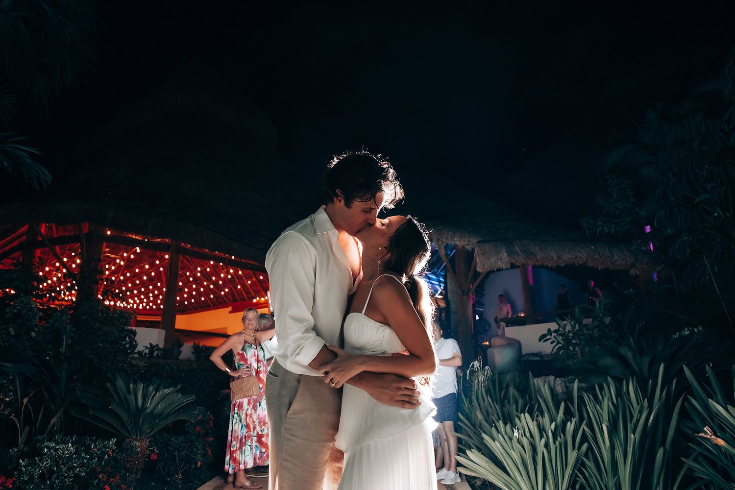 Intimate dance moment between newlyweds under dramatic evening lighting.