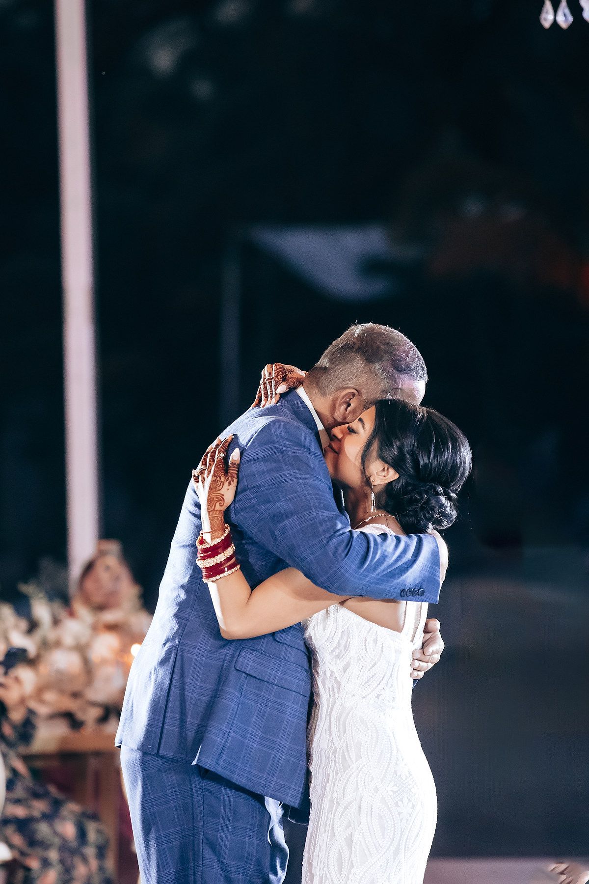 A couple embraces during an intimate dance at their wedding celebration.