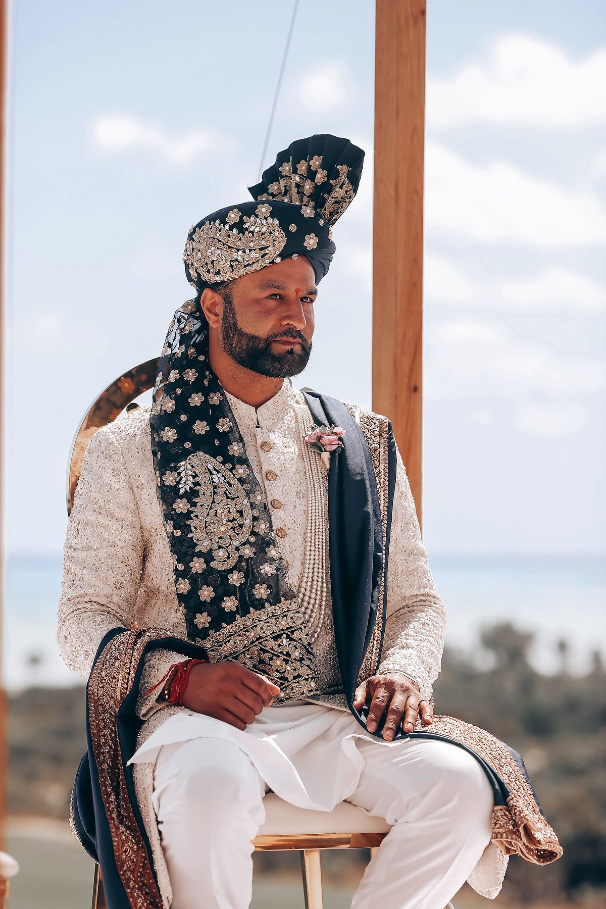 Traditional Indian wedding attire featuring ornate headpieces and cream-colored clothing.