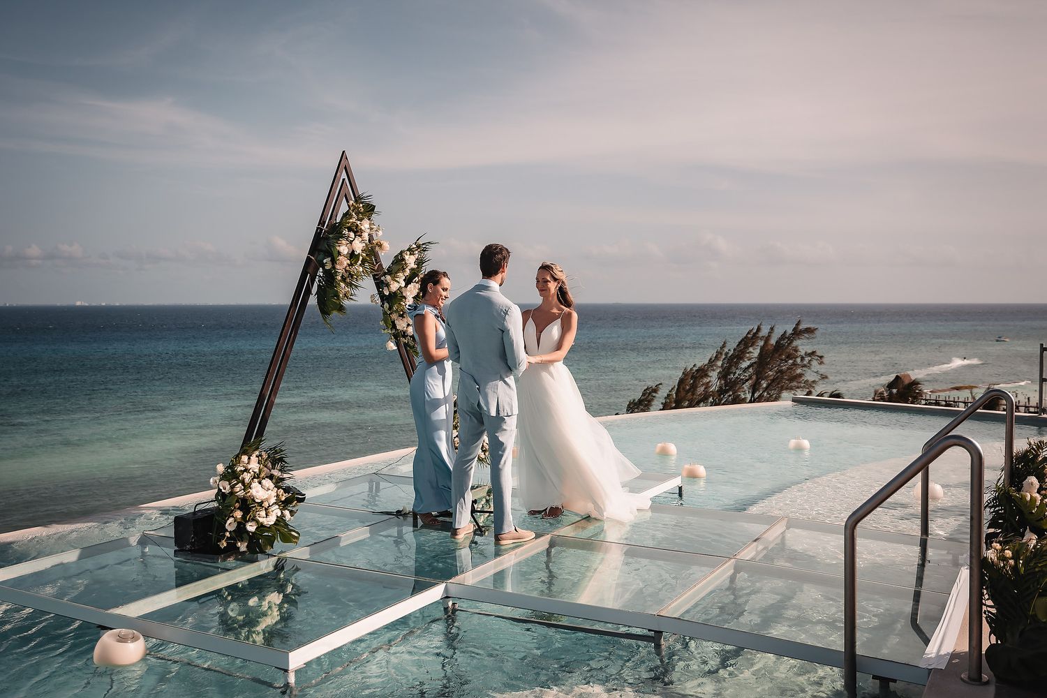 Minimalist wedding ceremony setup on infinity pool deck with ocean views.