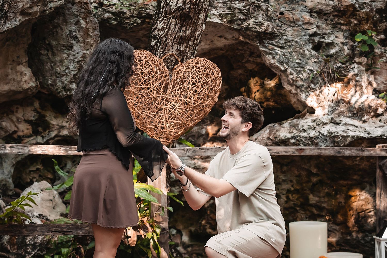 Intimate proposal scene arranged beside a turquoise cenote with decorative elements.