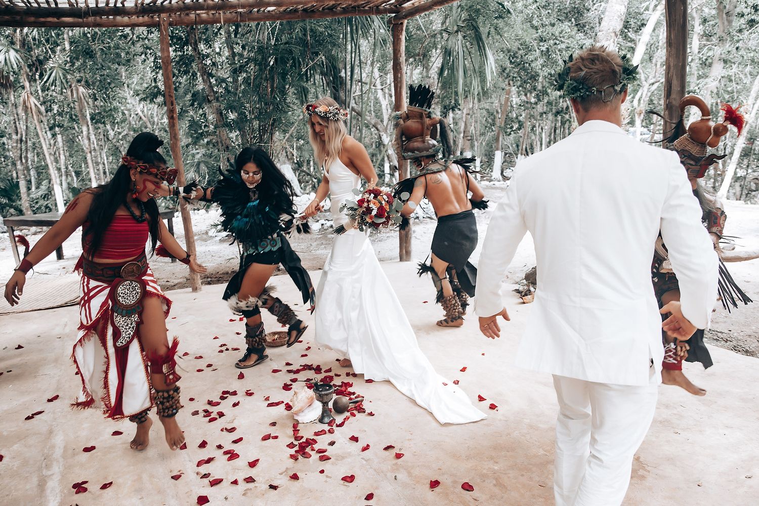 Rose petals scattered along a forest pathway during a wedding celebration.