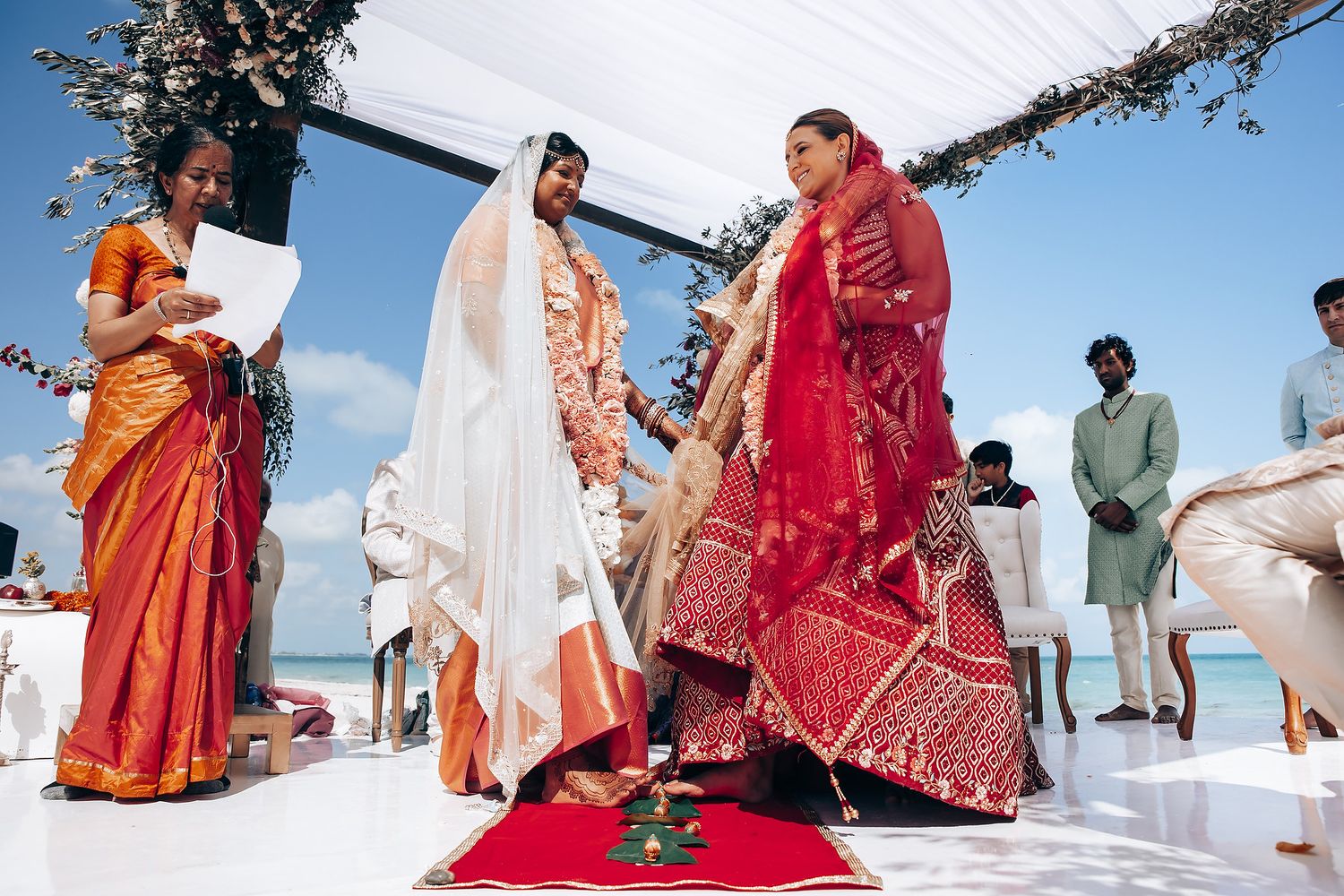 Outdoor Indian wedding celebration with guests in vibrant traditional attire gathered for festivities.