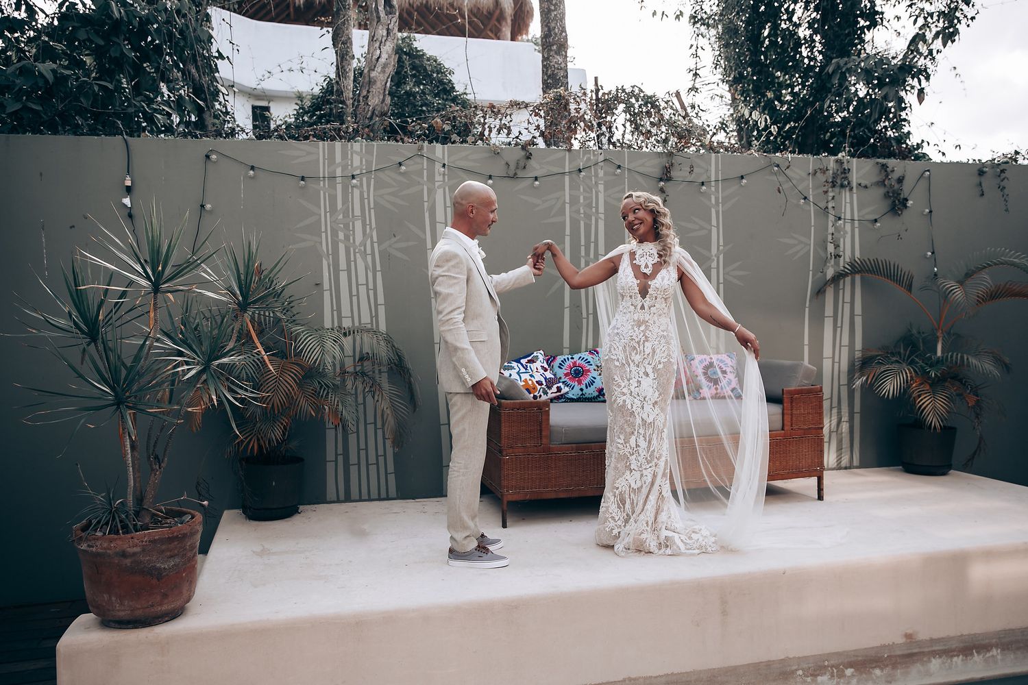 Couple sharing a moment during beach wedding ceremony with tropical decor.