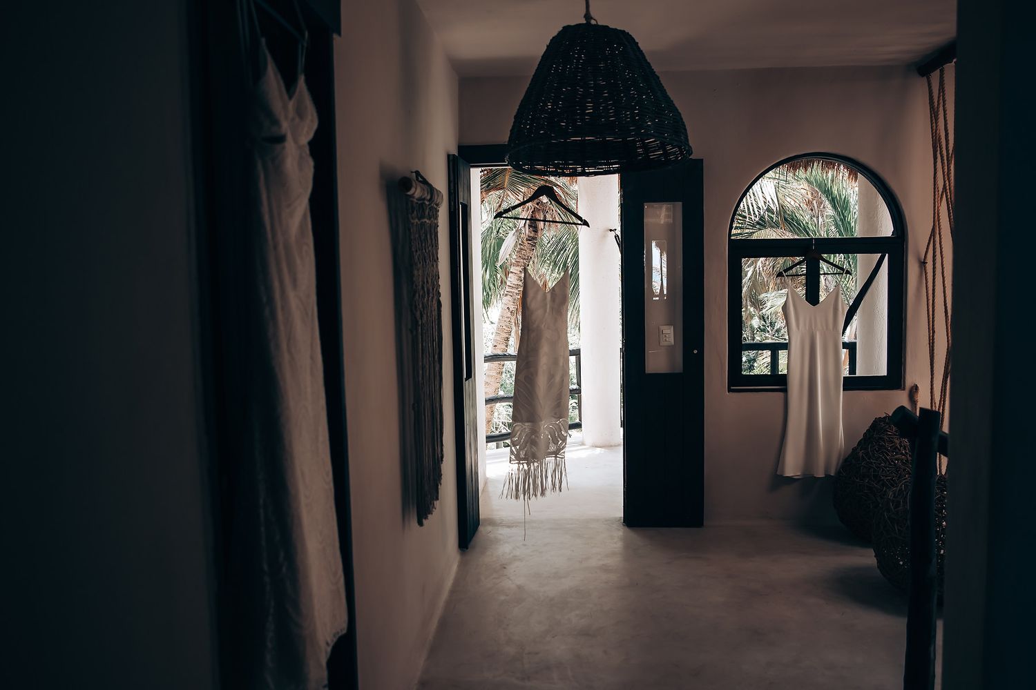 Dark hallway with arched doorways and windows creates dramatic lighting and shadows in a historic building interior.