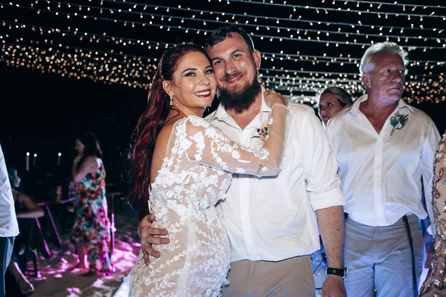 Wedding reception celebration under twinkling fairy lights at night.