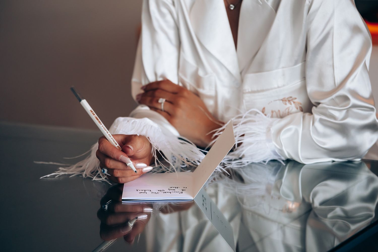 Wedding preparation details showing white formal attire and hands arranging items.