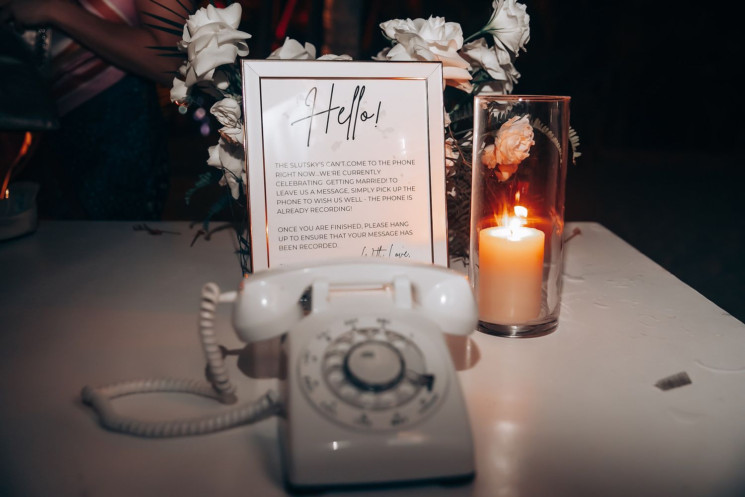 Vintage white telephone and candle display with wedding signage.