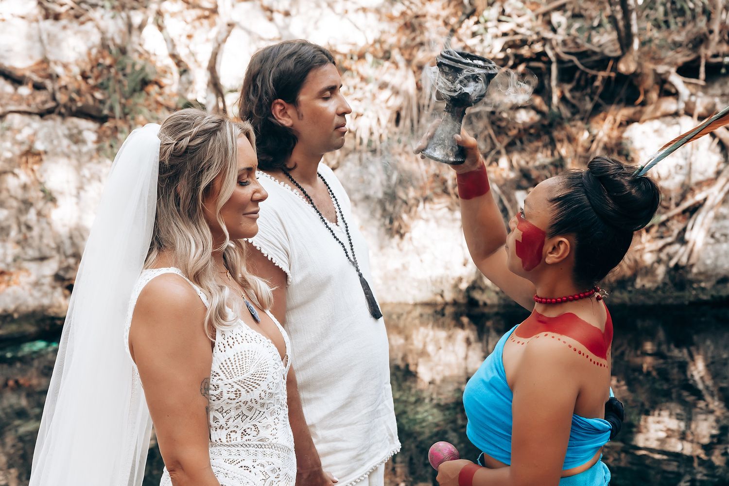 A group of people wearing white and colorful outfits share joyful moments together outdoors.