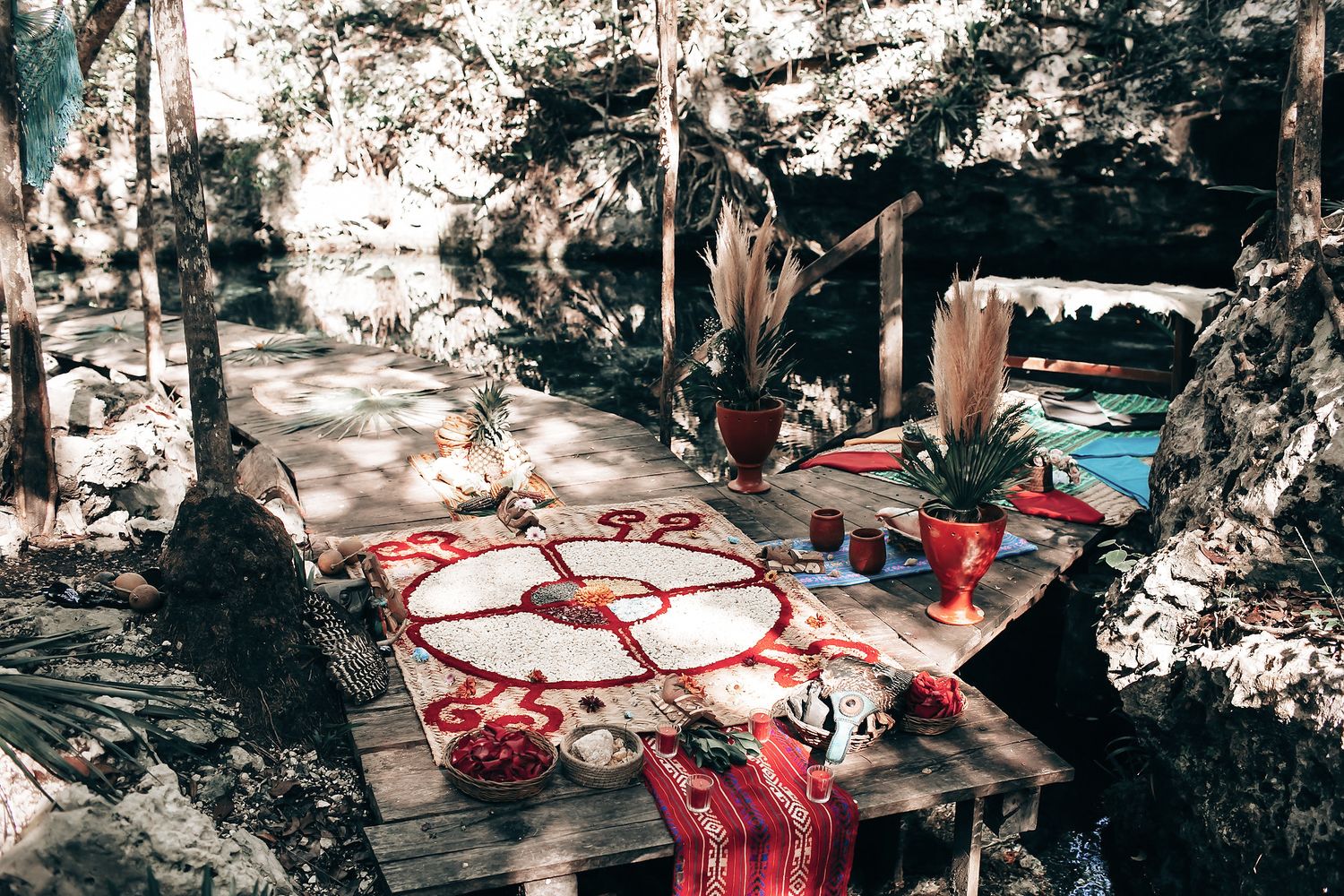 A colorful and whimsical outdoor seating area with a patterned rug, potted plants, and a rustic wooden table.