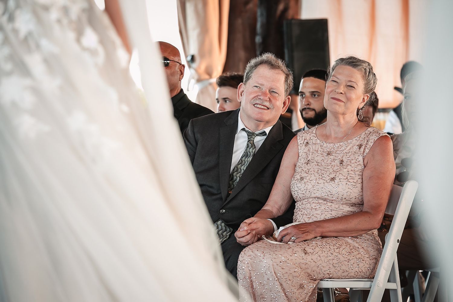 Wedding guests enjoying a celebration with laughter and smiles in a bright indoor venue.