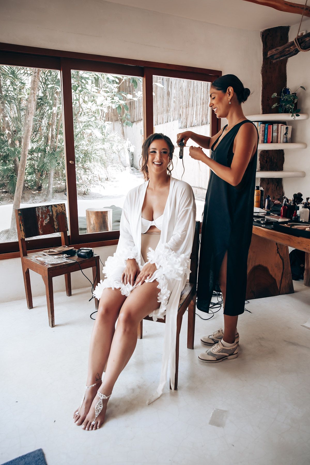 Interior preparation scene with white robes and natural lighting in a modern tropical room.