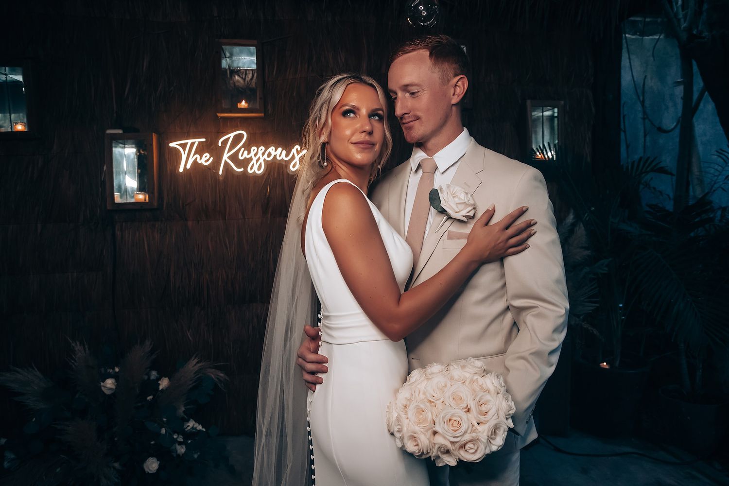 Newlyweds pose for romantic portraits in an elegant indoor venue with soft lighting.