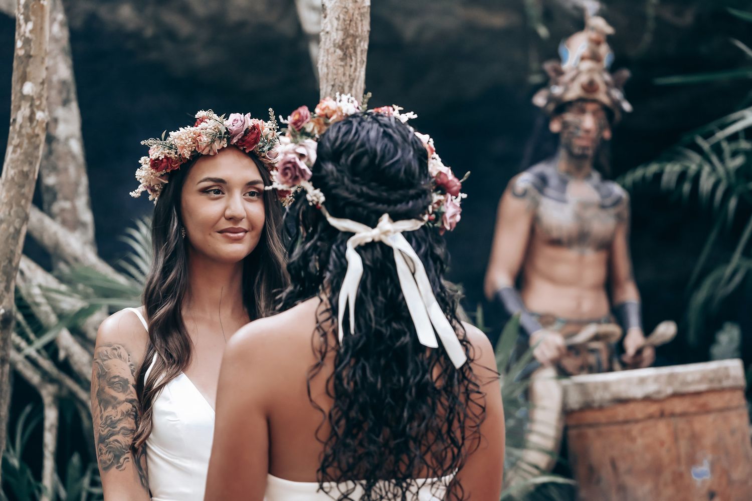 Traditional ceremony in tropical forest setting with floral crowns and cultural attire.