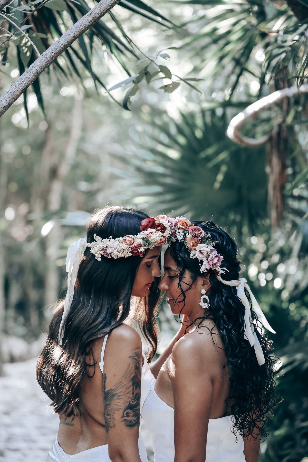 Romantic portrait of people wearing floral crowns in a tropical setting.