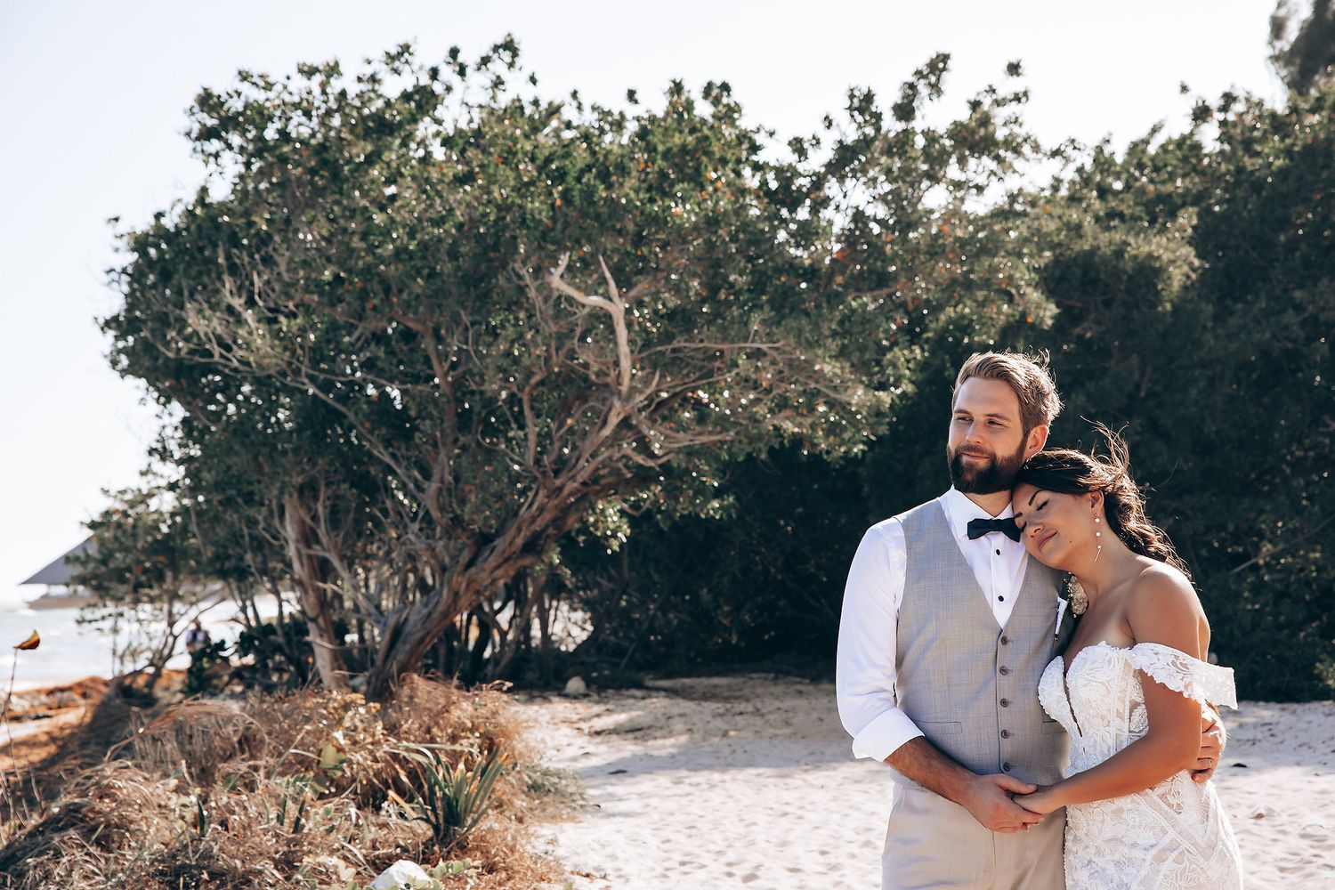 A couple shares an intimate moment during their wedding photoshoot in a natural outdoor setting.
