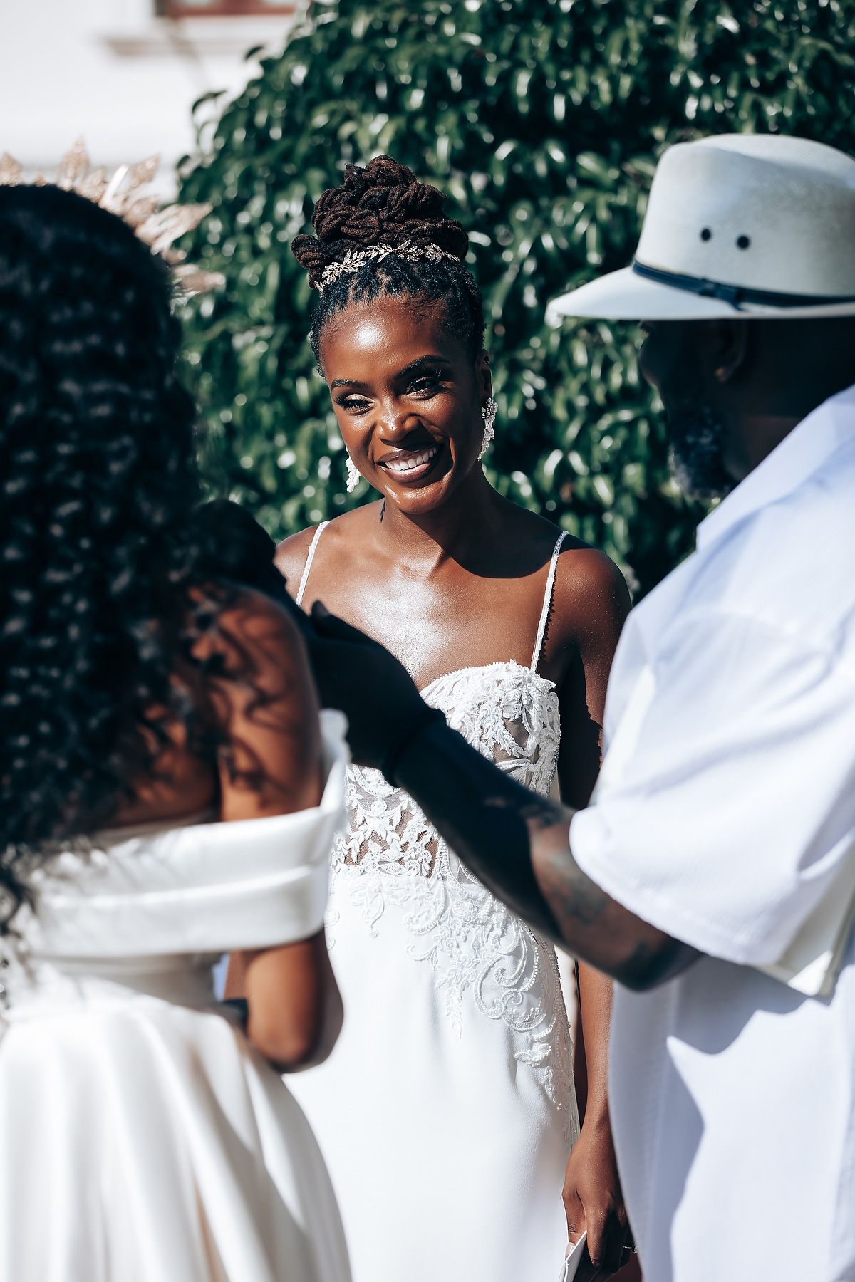 Wedding couple in white attire sharing intimate moments in a garden setting.
