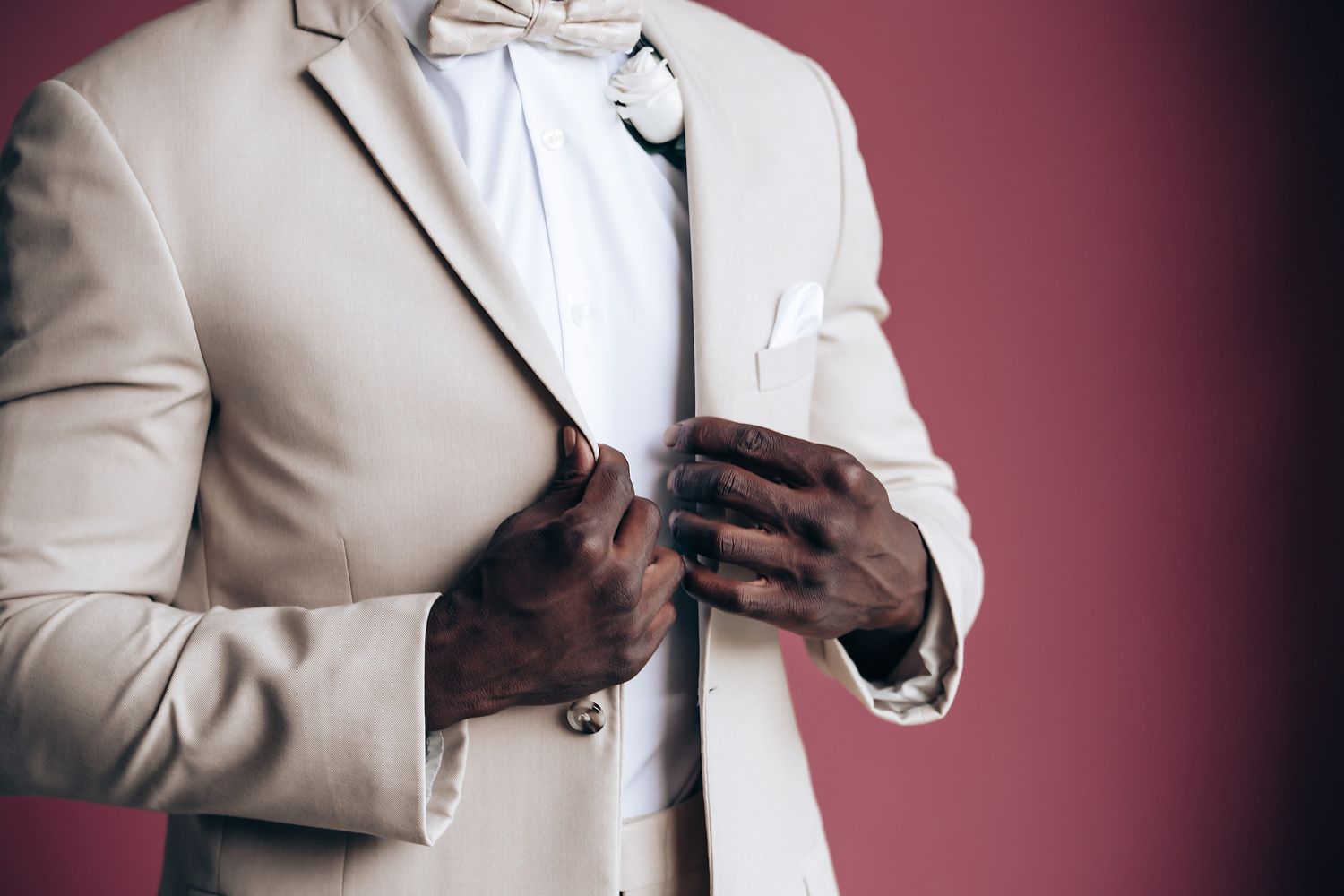 Details of a cream colored formal suit jacket and accessories.
