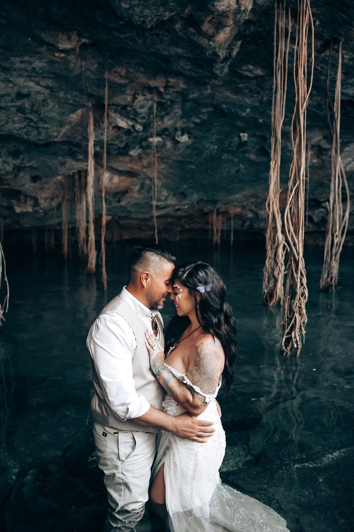 Romantic wedding photos captured in atmospheric cave setting with natural lighting.