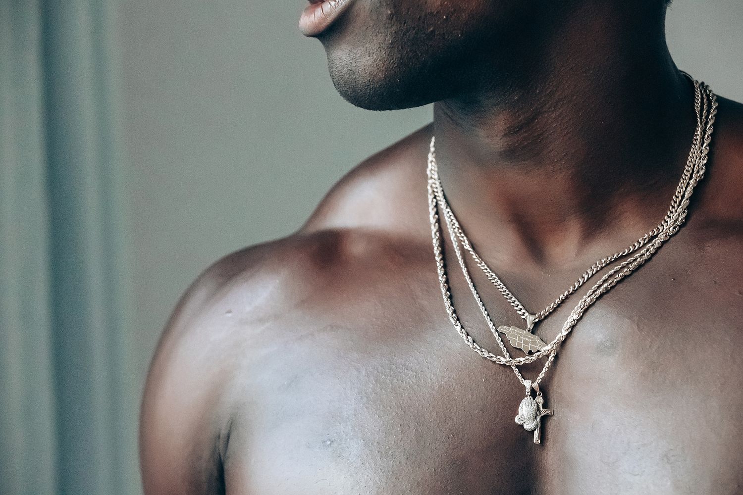 Image of a shirtless man with a beard and necklace.