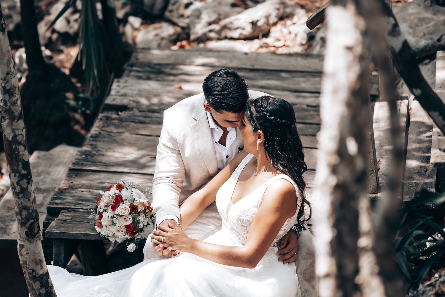 Intimate forest wedding ceremony with participants dressed in white performing traditional rituals.