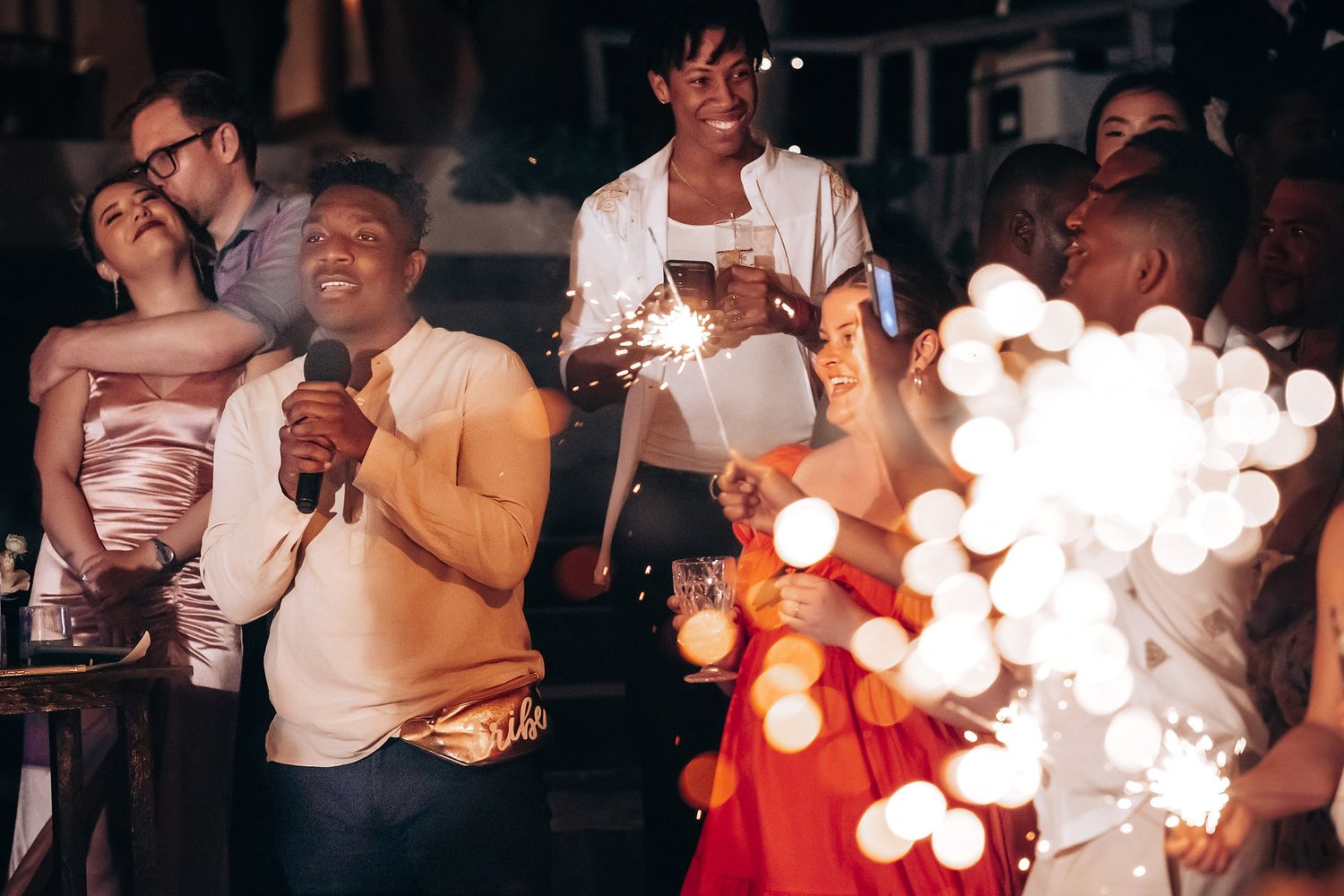 Couples dancing together at a festive evening celebration with warm lighting and bokeh effects in the background.
