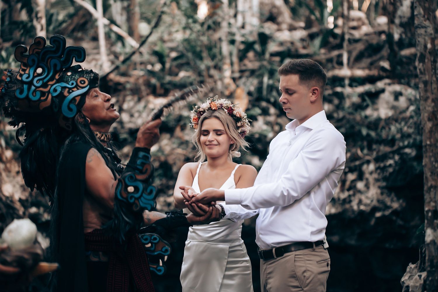 Wedding ceremony proceedings in progress within natural cave environment.