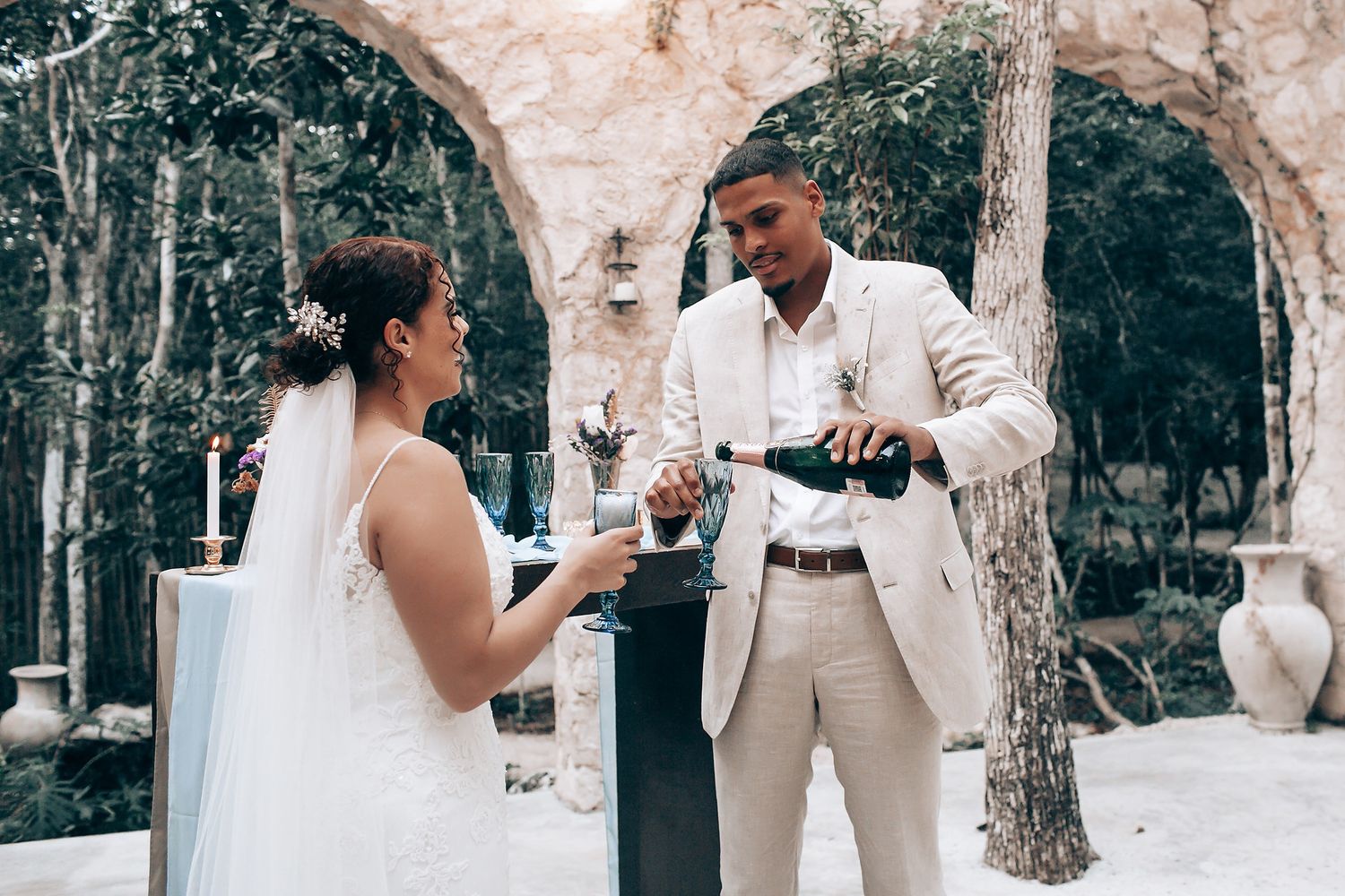 Wedding couple sharing intimate moments under rustic stone archways.