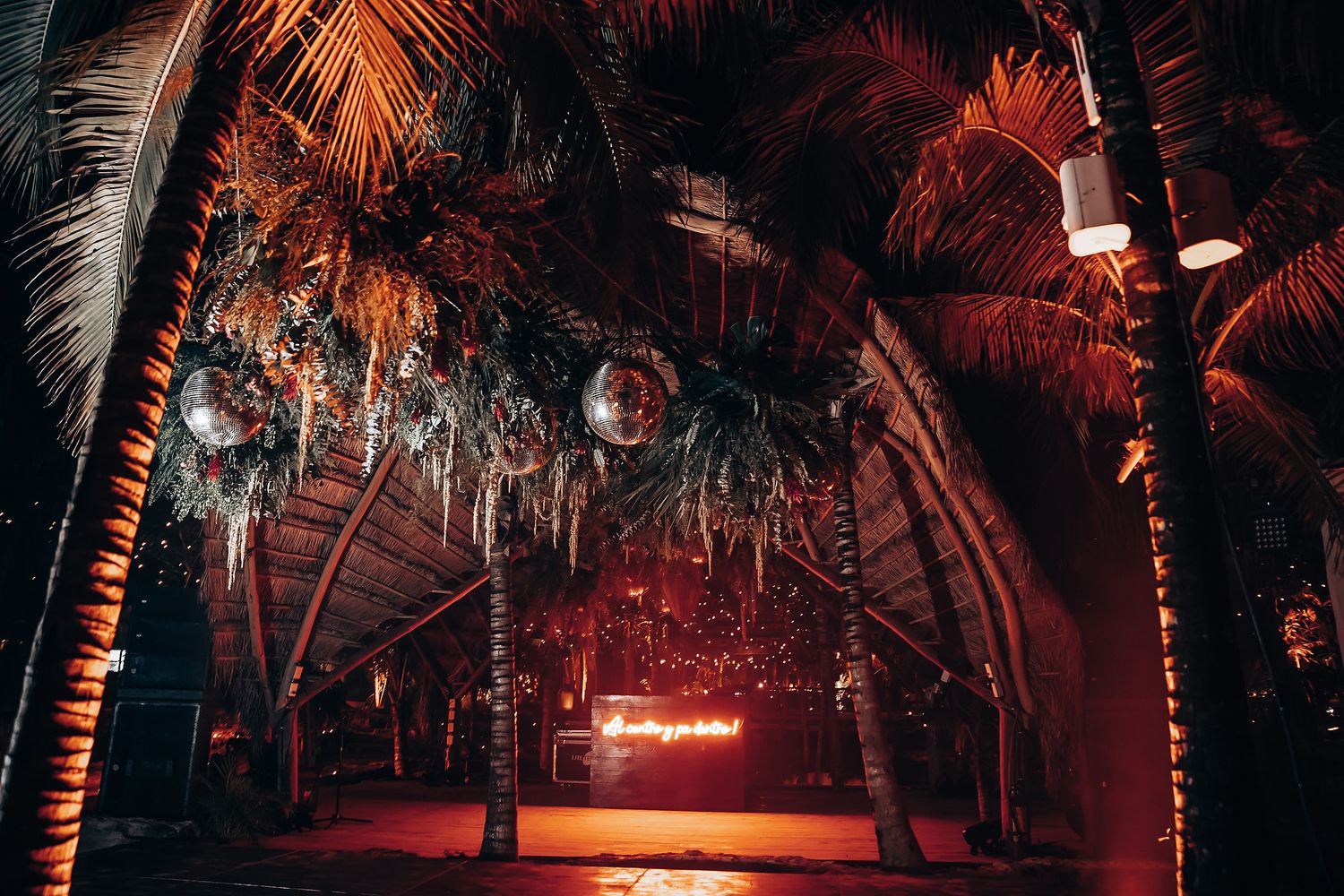 Moody nighttime scene with palm trees and red lighting creating a dramatic tropical atmosphere.
