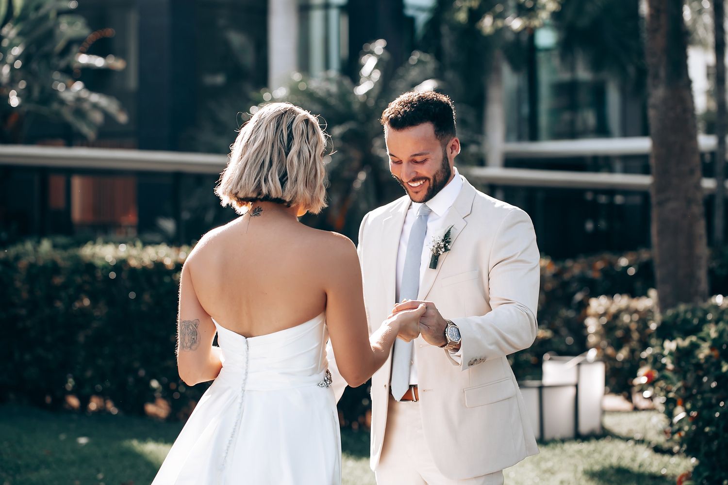 Couple sharing an emotional first look reaction in a garden setting with beautiful natural lighting.