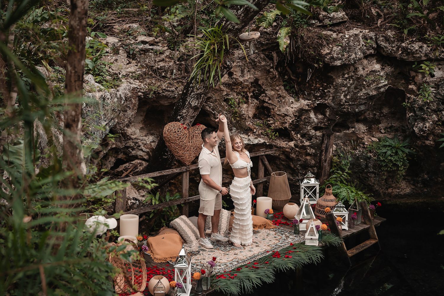 Romantic scene on wooden platform against rocky backdrop with decorative elements.