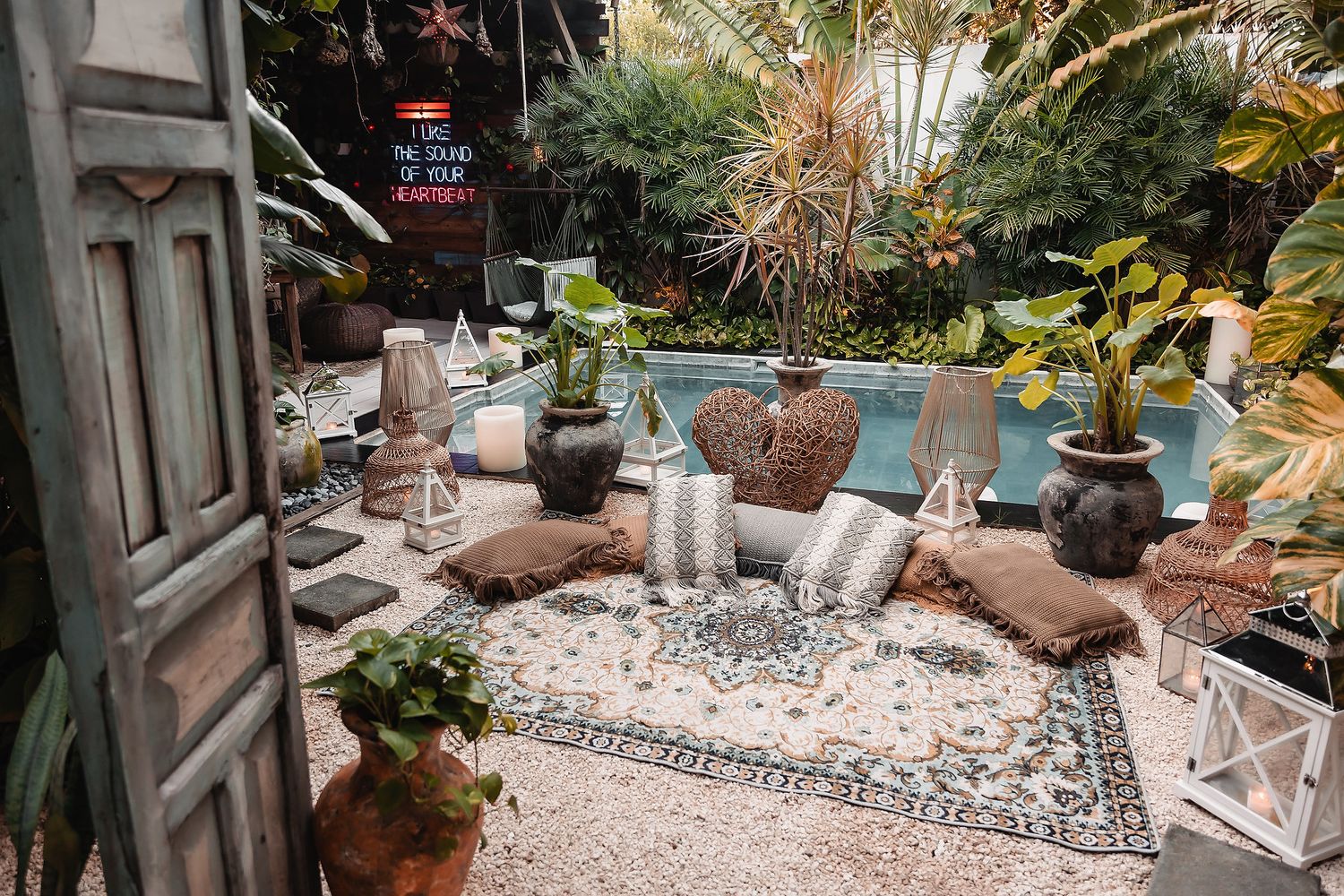 Tropical garden landscape with stone pathways and lush greenery surrounding a pool.