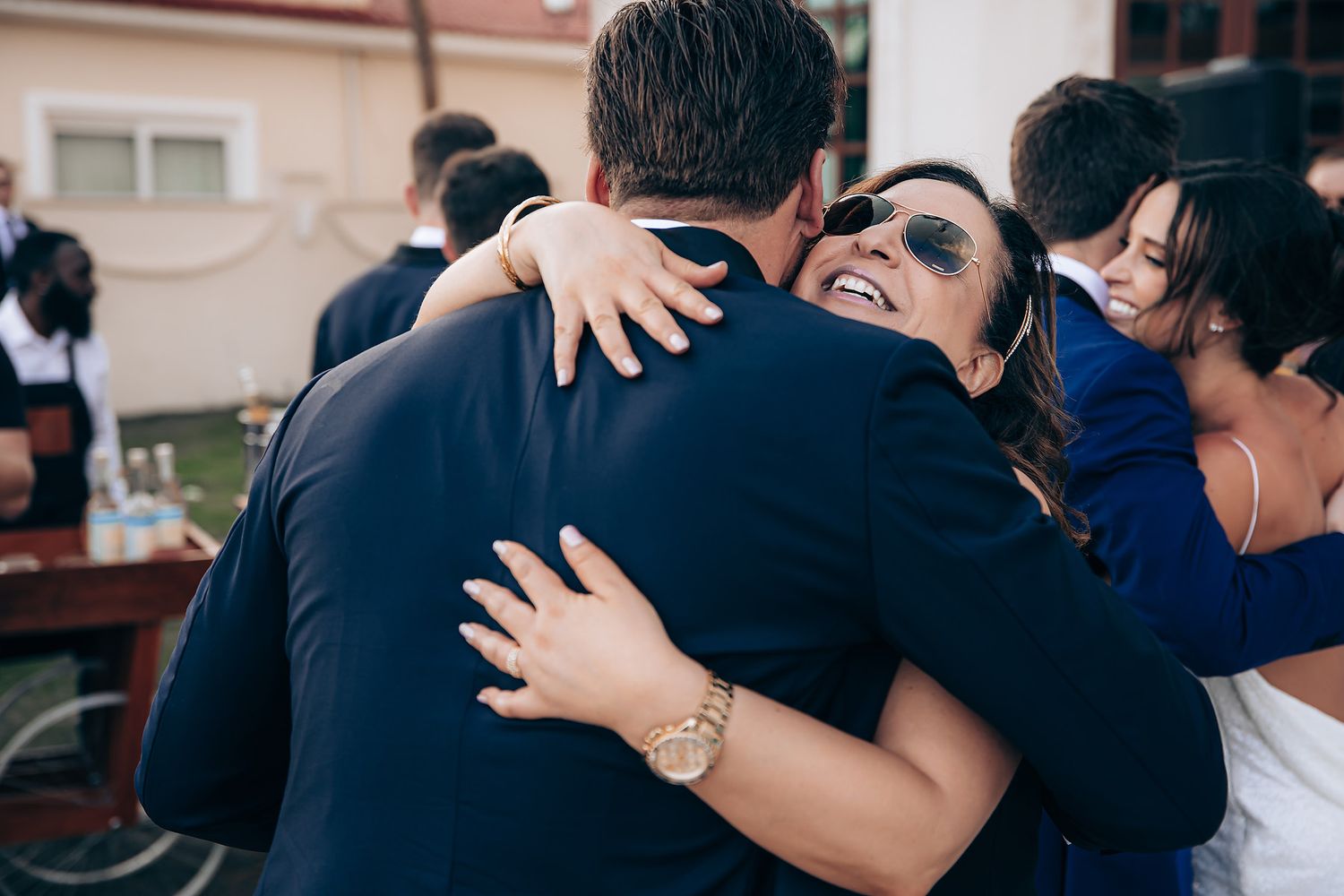 A series of emotional embraces and hugs between people wearing dark clothing at what appears to be a gathering.